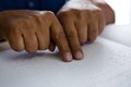 Cropped fingers on senior man reading braille book at table Royalty Free Stock Photo