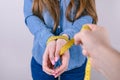 Cropped first person view close up photo of strict angry aggressive man male sport trainer holding yellow meter hands of his woman