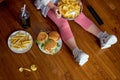 cropped girl eat crispy delicious potato chips and fast food sitting on floor Royalty Free Stock Photo