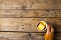 Cropped hand of caucasian woman wearing yellow sweater holding tea cup with lemon slice on table Royalty Free Stock Photo