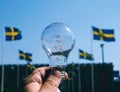 cropped hand holding light bulb against clear blue sky Royalty Free Stock Photo