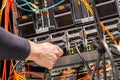 Male Technician Plugging Power Cable to Blade Server Cluster in Datacenter