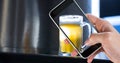 Cropped hand taking picture of beer glass at bar Royalty Free Stock Photo