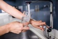 Cropped hand of woman filling water in glass