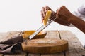 Cropped hands of african american chef grating cheese at table against white background, copy space Royalty Free Stock Photo