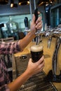 Cropped hands of barmaid pouring drink from tap in glass at counter Royalty Free Stock Photo