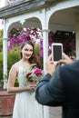 Cropped hands of bridegroom photographing bride at park Royalty Free Stock Photo