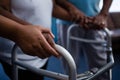 Cropped hands of nurse assisting woman in walking with walker Royalty Free Stock Photo