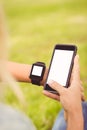 Cropped hands of person wearing smart watch and holding smartphone