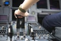 Cropped hands of pilot flying a commercial airplane, cockpit view close up of hands. Captain hand accelerating on the throttle in