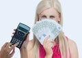 Cropped hands using calculator and beautiful woman holding currencies standing against white backgro Royalty Free Stock Photo