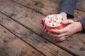 Cropped hands of woman holding mug of hot chocolate drink and marshmallows at table with copy space Royalty Free Stock Photo
