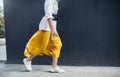 Cropped horizontal image of attractive woman in beautiful yellow skirt runing on the street. Caucasian female fashion model