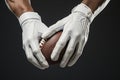 Cropped image of American football player holding an ovoid ball while standing against grey background. Muscular male Royalty Free Stock Photo