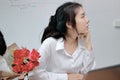 Cropped image of angry Asian woman refuses a bouquet of red roses from business man in office. Disappointed love concept.