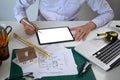 Architect man using digital tablet and working with construction plans at office. Royalty Free Stock Photo