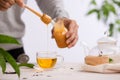 Cropped image of arista pouring honey into cup of tea Royalty Free Stock Photo