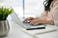 Cropped image of an Asian businesswoman using laptop, working in her office. side view Royalty Free Stock Photo