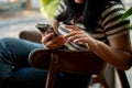 A cropped image of an Asian woman using her smartphone while relaxing in a cafe Royalty Free Stock Photo