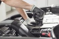 Cropped image of automobile mechanic repairing car in automobile store