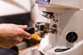 Cropped image of barista grinding fresh coffee into bayonet in coffee shop