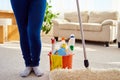 Cropped image of beautiful woman in protective gloves holding a flat wet-mop and bucket with detergents and rags while cleaning