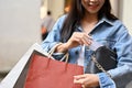 Cropped, Beautiful Asian woman carrying shopping bags, putting her credit card in her shoulder bag Royalty Free Stock Photo