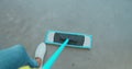 Cropped image of beautiful young woman in protective gloves using a flat wet-mop while cleaning floor in the house. Royalty Free Stock Photo