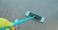 Cropped image of beautiful young woman in protective gloves using a flat wet-mop while cleaning floor in the house. Royalty Free Stock Photo