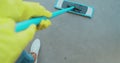 Cropped image of beautiful young woman in protective gloves using a flat wet-mop while cleaning floor in the house. Royalty Free Stock Photo