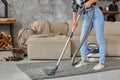 Cropped image of beautiful young woman using a vacuum cleaner while cleaning carpet in the house Royalty Free Stock Photo