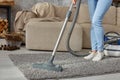 Cropped image of beautiful young woman using a vacuum cleaner while cleaning carpet in the house Royalty Free Stock Photo