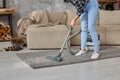 Cropped image of beautiful young woman using a vacuum cleaner while cleaning carpet in the house Royalty Free Stock Photo