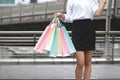 Cropped image of beauty Asian woman holding colorful shopping bags on city street. Royalty Free Stock Photo