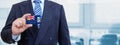 Cropped image of businessman holding plastic credit card with printed flag of Falkland Islands. Background blurred