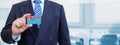 Cropped image of businessman holding plastic credit card with printed flag of Fiji. Background blurred