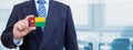Cropped image of businessman holding plastic credit card with printed flag of Guinea Bissau. Background blurred
