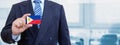 Cropped image of businessman holding plastic credit card with printed flag of Philippines. Background blurred