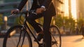 Cropped image of businessman riding a bicycle in the city at sunset