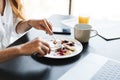 Cropped image of businesswoman having breakfast while working with laptop Royalty Free Stock Photo