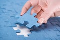 cropped image of businesswoman inserting last missing puzzle,