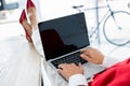 cropped image of businesswoman using laptop and sitting with legs on table in office