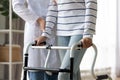 Cropped image caregiver helping to disabled patient walking with rollator