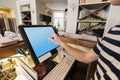 Cropped image of cashier touching computer screen at restaurant counter