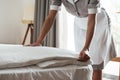 Cropped image of a chambermaid making bed in hotel room Royalty Free Stock Photo