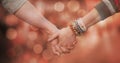 Cropped image of couple holding hands against bokeh Royalty Free Stock Photo