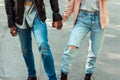 Cropped image of couple in stylish shoes and jeans standing together on one longboard Royalty Free Stock Photo