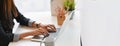 Cropped image of creative woman hands typing on a computer laptop that putting on a white working desk.