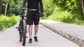 Cropped image of cycler holding bike in public park Royalty Free Stock Photo