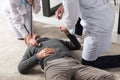 cropped image of doctor checking unconscious middle aged man